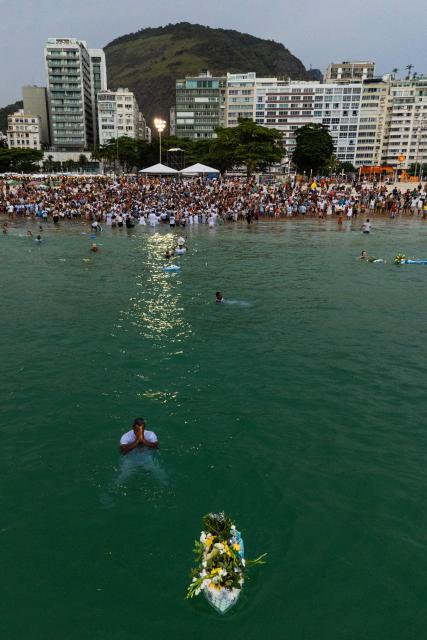 This aerial view shows worshippers paying tribute to Iemanja, the sea goddess of the Afro-Brazilian Umbanda religion, at Copacabana Beach in Rio de Janeiro, Brazil, on December 29, 2025. (Photo by IVAN PISARENKO / AFP)