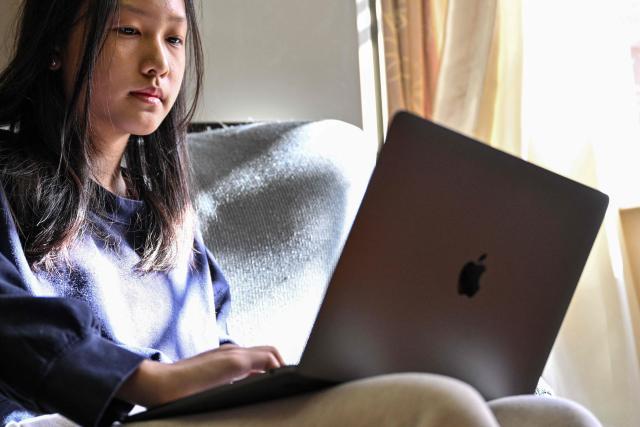 Estella, 14, a homeschooled student, attends a Spanish class in her home in Shanghai on November 25, 2025. They are among a small number of parents in China who are rethinking the country's rigorous education system, in which school days can last 10 hours, with students often working late into the evening on extra tutoring and homework. (Photo by Hector RETAMAL / AFP) / TO GO WITH: China-education-children-family, FOCUS by Mary YANG