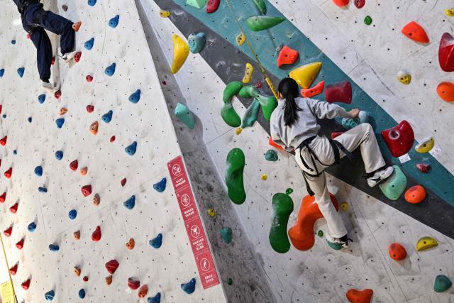 Estella, 14, a homeschooled student, climbs in an indoor rock climbing in Shanghai on November 25, 2025. They are among a small number of parents in China who are rethinking the country's rigorous education system, in which school days can last 10 hours, with students often working late into the evening on extra tutoring and homework. (Photo by Hector RETAMAL / AFP) / TO GO WITH: China-education-children-family, FOCUS by Mary YANG