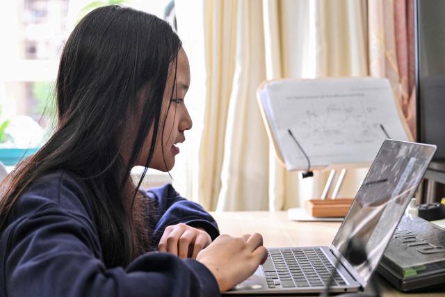 Estella, 14, a homeschooled student, attends a Spanish class in her home in Shanghai on November 25, 2025. They are among a small number of parents in China who are rethinking the country's rigorous education system, in which school days can last 10 hours, with students often working late into the evening on extra tutoring and homework. (Photo by Hector RETAMAL / AFP) / TO GO WITH: China-education-children-family, FOCUS by Mary YANG