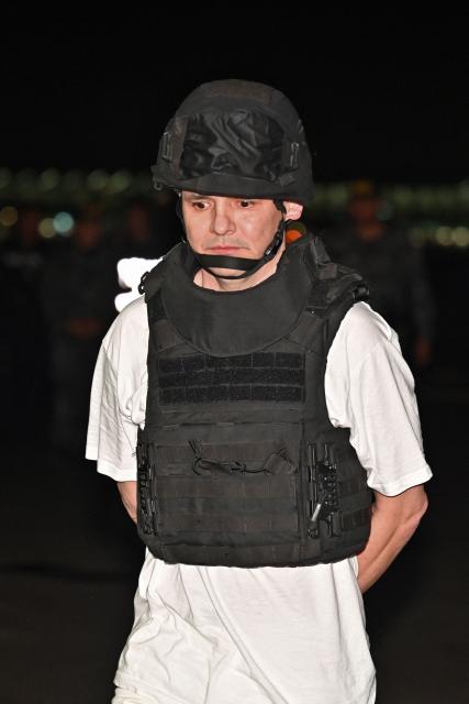 Roberto Alvarez, alias "El Gerente," an Ecuadorean alleged leader of a Colombian guerrilla group, is escorted upon landing at the Police base in Jose Joaquin de Olmedo International Airport in Guayaquil, Ecuador, on December 29, 2025, after being transferred from the United Arab Emirates. Alvarez, wanted by Ecuadorean authorities for the killing of 11 soldiers, has been identified by the government as the head of the Border Commands, a dissident faction of the now-defunct Colombian guerrilla group FARC that did not adhere to the 2016 peace agreement. (Photo by Marcos PIN / AFP)