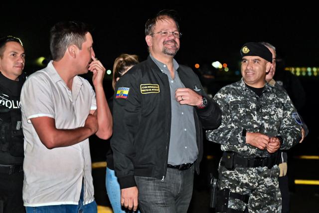 Ecuador's Interior Minister John Reimberg (C) and Commander-in-Chief of Ecuador's National Police, Pablo Davila (R) wait for the arrival of Roberto Alvarez, alias "El Gerente," an Ecuadorean alleged leader of a Colombian guerrilla group, at the Police base in Jose Joaquin de Olmedo International Airport in Guayaquil, Ecuador, on December 29, 2025, after being transferred from the United Arab Emirates. Alvarez, wanted by Ecuadorean authorities for the killing of 11 soldiers, has been identified by the government as the head of the Border Commands, a dissident faction of the now-defunct Colombian guerrilla group FARC that did not adhere to the 2016 peace agreement. (Photo by Marcos PIN / AFP)