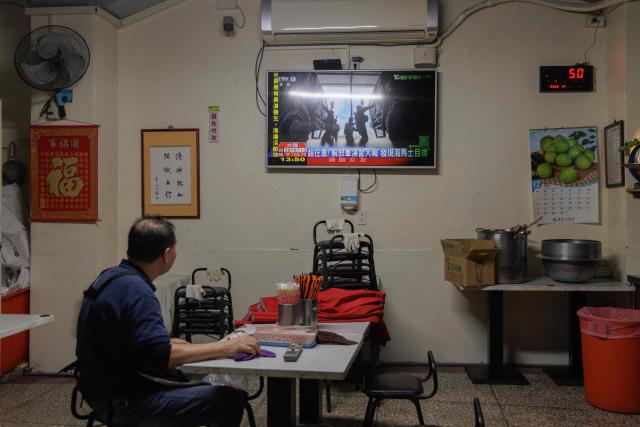 A man watches TV news coverage of the Chinese People’s Liberation Army (PLA) military drills around Taiwan in Keelung on December 30, 2025. China launched missiles and deployed dozens of fighter aircraft and navy vessels around Taiwan on December 30 for a second day of live-fire drills aimed at simulating a blockade of the self-ruled island's key ports and assaults on maritime targets. (Photo by CHENG Yu-chen / AFP)