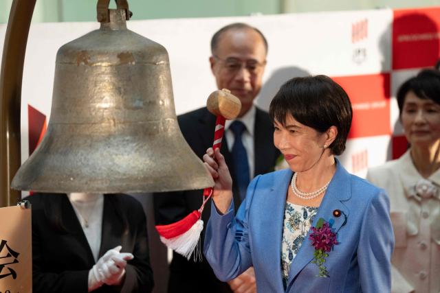 Japan’s Prime Minister Sanae Takaichi hits the bell to mark the closure of the end-of-year trading session at the Tokyo Stock Exchange (TSE) in Tokyo on December 30, 2025. (Photo by Yuichi YAMAZAKI / AFP)
