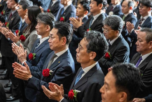 Guests applaud during a ceremony to mark the closure of the end-of-year trading session at the Tokyo Stock Exchange (TSE) in Tokyo on December 30, 2025. (Photo by Yuichi YAMAZAKI / AFP)