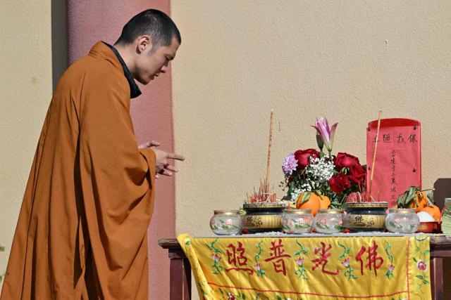 A monk prays at a temple on Pingtan island, the closest point to Taiwan, in eastern China’s Fujian province on December 30, 2025. China's military drills around Taiwan entered their second day on December 30, the sixth major manoeuvres Beijing has held near the self-ruled island in recent years. (Photo by ADEK BERRY / AFP)
