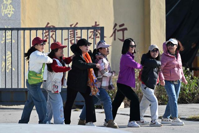 Visitors pose for photos on Pingtan island, the closest point to Taiwan, in eastern China’s Fujian province on December 30, 2025. China's military drills around Taiwan entered their second day on December 30, the sixth major manoeuvres Beijing has held near the self-ruled island in recent years. (Photo by ADEK BERRY / AFP)