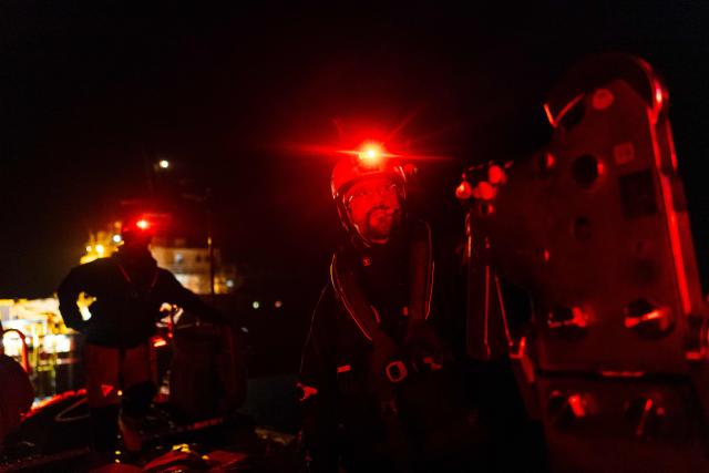 Crew members of the “Ocean Viking” rescue ship, operated by the French NGO SOS Mediterranee, take part in a team night exercise to prepare for a rescue situation at sea with a "RHIB", an inflatable dinghy, on their way to the search-and-rescue zone in international waters in the Mediterranean Sea, on December 29, 2025. Migrants rescue ship "Ocean Viking" is preparing to return to operations following the attack it suffered on August 24, 2025 when Libyan Coast Guard forces fired directly on the rescue vessel operated by the NGO SOS Mediterranee. (Photo by Sameer Al-DOUMY / AFP)