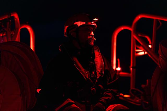Search and Rescue (SAR) team's leader of the “Ocean Viking” rescue ship, operated by the French NGO SOS Mediterranee, takes part in a team night exercise to prepare for a rescue situation at sea with a "RHIB", an inflatable dinghy, on their way to the search-and-rescue zone in international waters in the Mediterranean Sea, on December 29, 2025. Migrants rescue ship "Ocean Viking" is preparing to return to operations following the attack it suffered on August 24, 2025 when Libyan Coast Guard forces fired directly on the rescue vessel operated by the NGO SOS Mediterranee. (Photo by Sameer Al-DOUMY / AFP)