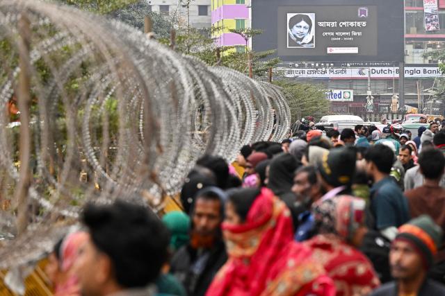 A billboard featuring Bangladesh's late prime minister Khaleda Zia is displayed outside the barricaded Evercare hospital in Dhaka on December 30, 2025. Zia, who many believed would sweep elections next year to lead her country once again, died on December 30 aged 80, her Bangladesh Nationalist Party (BNP) said. (Photo by Munir UZ ZAMAN / AFP)