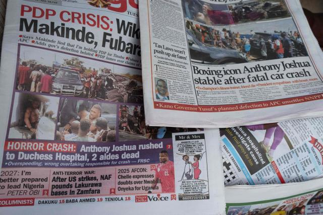 Newspapers bearing headlines about a road accident involving British boxer Anthony Joshua, who was hospitalized in stable condition after a crash that killed two people, are displayed at a stall in Abeokuta on December 30, 2025. Former world heavyweight boxing champion Anthony Joshua was in a "stable condition" in hospital after a car accident in Nigeria that killed two close friends and associates, his promoter announced on December 29, 2025.
Matchroom confirmed police and media reports that he was involved in the smash, which happened on December 29, 2025 morning on a main road linking Lagos and Ibadan in the southwest of the country. (Photo by TOYIN ADEDOKUN / AFP)
