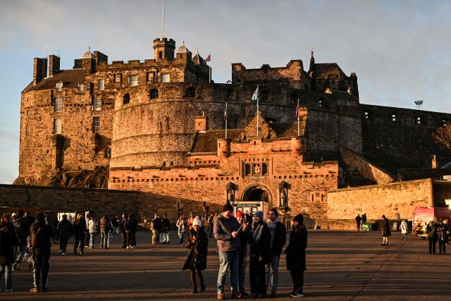 This general view shows tourists outside Edinburgh Castle on December 30, 2025, ahead of the annual Hogmanay street party which culminates in a midnight fireworks display over the castle. An estimated 100,000 people from dozens of countries are expected in Edinburgh for the New Year events, the centrepiece of which is a street party and fireworks display on December 31. (Photo by Andy Buchanan / AFP)
