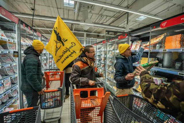Members of the Confederation Rurale (CR) and Confederation paysanne farmers unions fill shopping carts with imported goods during an action to denounce the import of foreign products at a supermarket in Carcassonne, southern France, on December 30, 2025. French farmers have been fuming over a litany of issues, including a trade deal under negotiation between the European Union and South American bloc Mercosur, with any further decisions postponed to January. (Photo by Idriss Bigou-Gilles / AFP)