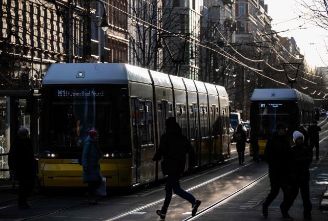 A commuter rushes to catch a tramway of the BVG (Berliner Verkehrsbetriebe, "Berlin Transport Company"), the main purveyor of the capital's public transport, in Berlin on December 30, 2025. BVG prices will increase in January 2026, with
single tickets rising to EUR 4.00 (from 3.80) and the popular Deutschlandticket going up to  EUR 63 monthly, as part of an average 6% fare hike across the region to cover rising costs. (Photo by John MACDOUGALL / AFP)