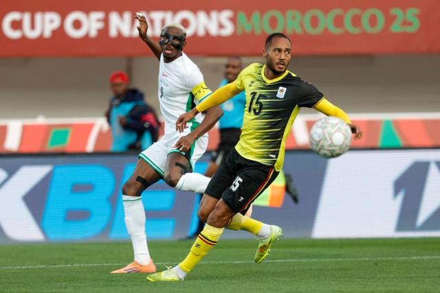 Nigeria's forward #09 Victor Osimhen and Uganda's defender #15 Jordan Obita during the Africa Cup of Nations (CAN) Group C football match between Uganda and Nigeria at Fez Stadium in Fez on December 30, 2025. (Photo by Abdel Majid BZIOUAT / AFP)