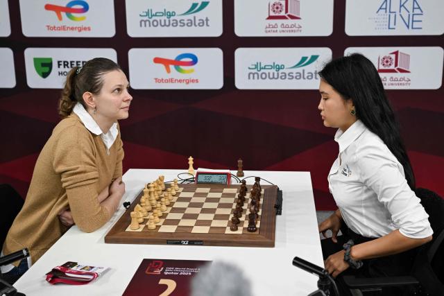 Ukraine's Anna Muzychuk (L) plays against Kazakhstan's Bibisara Assaubayeva in the final round of the FIDE World Rapid and Blitz Championship at Qatar University's Sports and Events Complex in Doha on December 30, 2025. (Photo by MAHMUD HAMS / AFP)