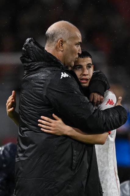Tunisia's head coach Samy Trabelsi congratulates Tunisia's midfielder #11 Ismael Gharbi after the Africa Cup of Nations (CAN) Group C football match between Tanzania and Tunisia at Rabat Olympic Stadium in Rabat on December 30, 2025. (Photo by Paul ELLIS / AFP)