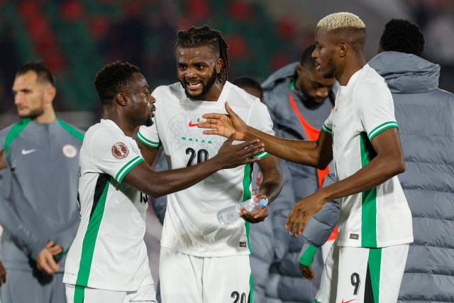 Nigeria's defender #20 Chidozie Awaziem celebrates with Nigeria's forward #15 Moses Simon and Nigeria's forward #09 Victor Osimhen after the Africa Cup of Nations (CAN) Group C football match between Uganda and Nigeria at Fes Stadium in Fes on December 30, 2025. (Photo by Abdel Majid BZIOUAT / AFP)