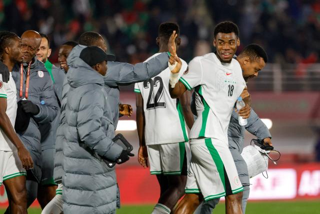 Nigeria's midfielder #18 Raphael Onyedika celebrates with teammates after the Africa Cup of Nations (CAN) Group C football match between Uganda and Nigeria at Fes Stadium in Fes on December 30, 2025. (Photo by Abdel Majid BZIOUAT / AFP)