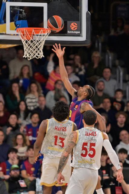 Barcelona's US guard #0 Kevin Punter drives to the basket past AS Monaco's US centre #13 Kevarrius Hayes during the Euroleague basketball between FC Barcelona and Monaco at Palau Blaugrana Arena in Barcelona, Spain on December 30, 2025. (Photo by MANAURE QUINTERO / AFP)