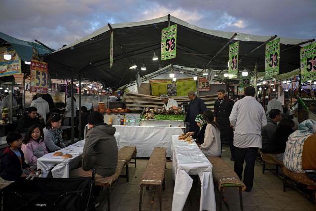 A Moroccan chef prepares a dish of lamb at an open air restaurant in the Jemaa el-Fna square in Marrakesh on December 30, 2025. (Photo by Khaled DESOUKI / AFP)