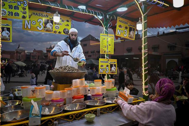 A Moroccan chef serves a snail dish for customers in the Jemaa el-Fna square in Marrakesh on December 30, 2025. (Photo by Khaled DESOUKI / AFP)