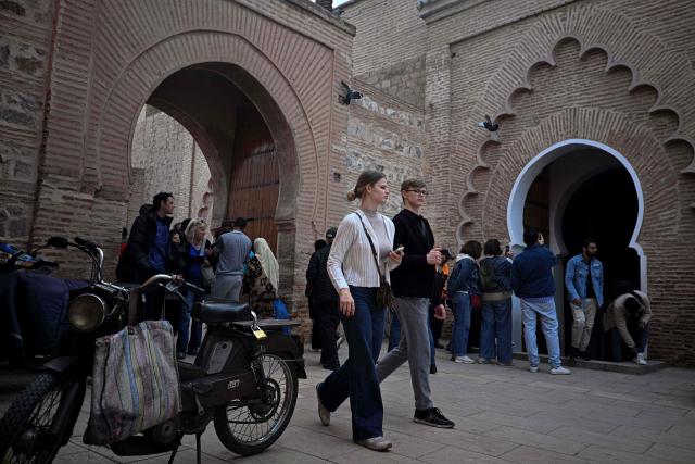 People walk near the Koutoubia Mosque in Marrakesh on December 30, 2025. (Photo by Khaled DESOUKI / AFP)