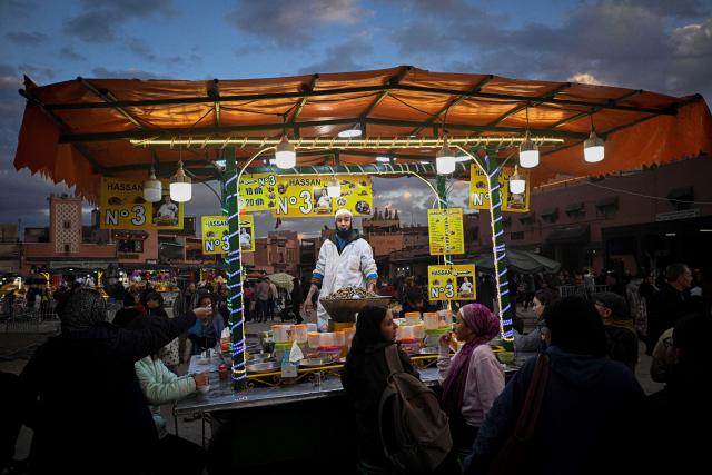 TOPSHOT - A Moroccan chef serves a snail dish for customers in the Jemaa el-Fna square in Marrakesh on December 30, 2025. (Photo by Khaled DESOUKI / AFP)