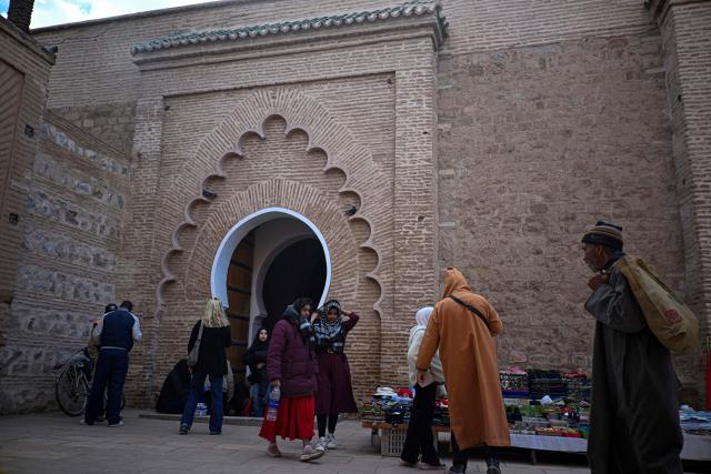 People walk near the Koutoubia Mosque in Marrakesh on December 30, 2025. (Photo by Khaled DESOUKI / AFP)