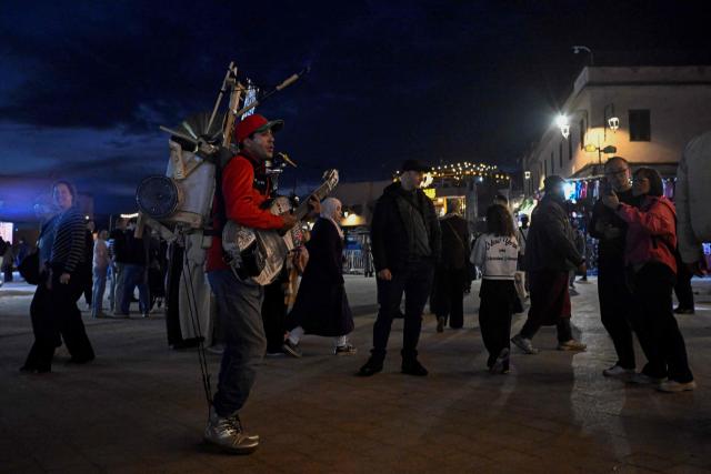 A street musician performs in the Jemaa el-Fnaa square in Marrakesh on December 30, 2025. (Photo by Khaled DESOUKI / AFP)