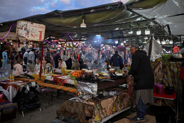 A Moroccan chef serves kebab for customers in the Jemaa el-Fnaa square in Marrakesh on December 30, 2025. (Photo by Khaled DESOUKI / AFP)