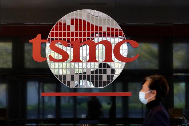 (FILES) A man walks past a company logo at the headquarters of the world's largest semiconductor maker TSMC in Hsinchu on January 29, 2021. Taiwanese tech titan TSMC has started mass producing its cutting-edge 2-nanometre semiconductor chips, the company said in a statement seen by AFP on December 31, 2025. (Photo by Sam Yeh / AFP)