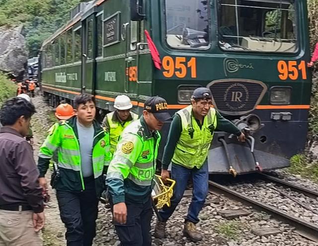 Police officers carry an injured passenger from one of the two trains affected after a head-on collision connecting Machu Picchu with Ollantaytambo in Pampacahua, Cusco Department, Peru, on December 30, 2025. On December 30, 2025, a head-on collision between two trains on the line that services Peru's Machu Picchu killed one person and injured at least 40 others, authorities said, updating an earlier toll. (Photo by Carolina Paucar / AFP)