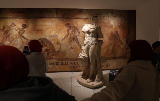 Libyans visit the National Museum after its reopening, following a closure of more than a decade in the Libyan capital Tripoli on December 23, 2025. In a historic building in central Tripoli, Libyans wander past ancient statues and artefacts, rediscovering a heritage that transcends political divides at their national museum which reopened this month after a 2011 uprising. (Photo by Mahmud Turkia / AFP)