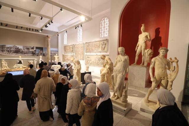 Libyan families and students visit the National Museum after its reopening, following a closure of more than a decade in the Libyan capital Tripoli on December 23, 2025. In a historic building in central Tripoli, Libyans wander past ancient statues and artefacts, rediscovering a heritage that transcends political divides at their national museum which reopened this month after a 2011 uprising. (Photo by Mahmud Turkia / AFP)