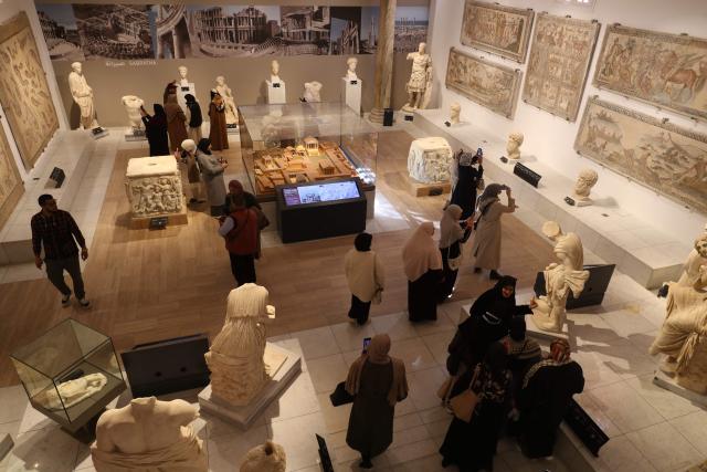 Libyans visit the National Museum after its reopening, following a closure of more than a decade in the Libyan capital Tripoli on December 23, 2025. In a historic building in central Tripoli, Libyans wander past ancient statues and artefacts, rediscovering a heritage that transcends political divides at their national museum which reopened this month after a 2011 uprising. (Photo by Mahmud Turkia / AFP)
