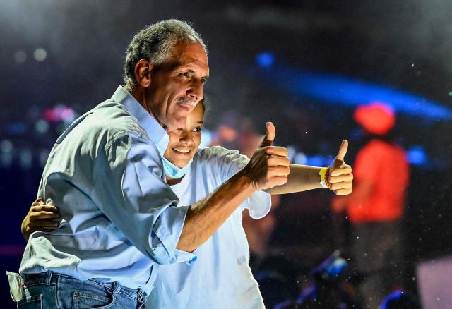 (FILES) Tegucigalpa's Mayor and presidential candidate for the ruling National Party Nasry Asfura, aka "Papi a la Orden" (L), hugs a supporter during the campaign closing event, in Tegucigalpa on November 21, 2021. Honduran President-elect Nasry Asfura, backed by US President Donald Trump, will govern with a weak majority in Congress that will force him to forge alliances, according to the final composition of the legislature announced on December 30, 2025. (Photo by Orlando SIERRA / AFP)