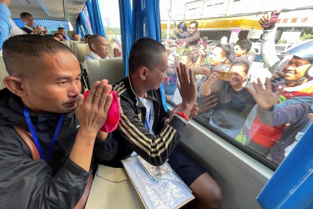 TOPSHOT - Cambodian soldiers, who had been captured by Thai soldiers in July, gesture to well-wishers from a bus after their release, near a checkpoint along the border with Thailand, in Cambodia's Pailin province on December 31, 2025. Thailand on December 31 released 18 Cambodian soldiers captured in July, both governments said, after a fresh ceasefire between the neighbours held for more than three days following weeks of deadly border clashes. (Photo by AFP)