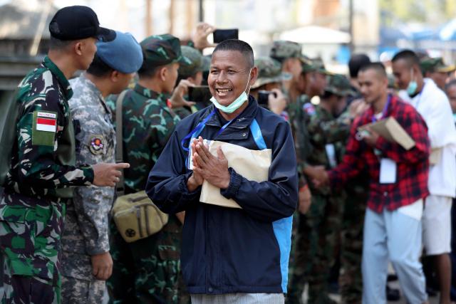 A Cambodian soldier, who had been captured by Thai soldiers in July, smiles after his release, as he walks at a checkpoint along the border with Thailand, in Cambodia's Pailin province on December 31, 2025. Thailand on December 31 released 18 Cambodian soldiers captured in July, both governments said, after a fresh ceasefire between the neighbours held for more than three days following weeks of deadly border clashes. (Photo by AFP)