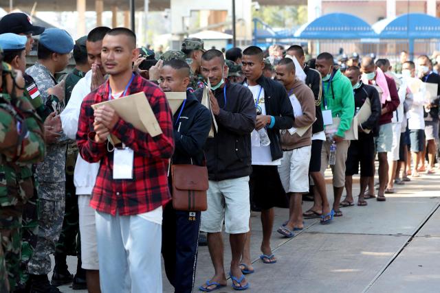 Cambodian soldiers, who had been captured by Thai soldiers in July, are greeted after their release, as they walk at a checkpoint along the border with Thailand, in Cambodia's Pailin province on December 31, 2025. Thailand on December 31 released 18 Cambodian soldiers captured in July, both governments said, after a fresh ceasefire between the neighbours held for more than three days following weeks of deadly border clashes. (Photo by AFP)