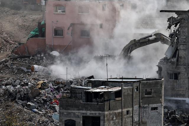An Israeli military excavator tears down one of 25 residential buildings earmarked for demolition in the Nur Shams camp Palestinian refugees east of the northern Israeli-occupied West Bank city of Tulkarem, amid an ongoing offensives in the occupied-West Bank on December 31, 2025. In mid December the Israeli army said it would demolish 25 residential buildings in the north West Bank's Nur Shams refugee camp, local authorities told AFP. In early 2025, Israel's military launched a wide-ranging and still ongoing operation it says is aimed at rooting out Palestinian armed groups from refugee camps in the northern West Bank -- including the Nur Shams, Tulkarem and Jenin camps. (Photo by Zain JAAFAR / AFP)