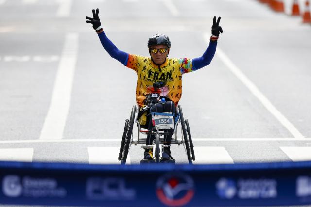 Brazilian wheelchair runner Franciomar Bastos Franco crosses the finish line to win the men's 15km competition of the 100th edition of the Saint Silvestre road race in Sao Paulo, Brazil, on December 31, 2025. (Photo by Miguel SCHINCARIOL / AFP)