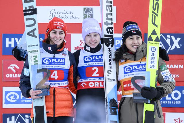 (L-R) Second-placed Selina Freitag of Germany, first-placed Nika Prevc of Slovenia and third-placed Nozomi Maruyama of Japan celebrate on the podium during the winner’s ceremony of the FIS Ski Jumping Two Nights Tour women's World Cup in Garmisch-Partenkirchen southern Germany on December 31, 2025. (Photo by Philipp Guelland / AFP)
