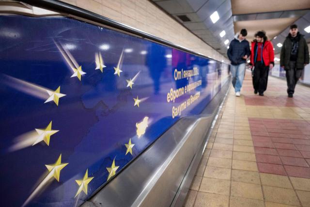 Commuters walk past an advertisement promoting Bulgaria's entry into the Eurozone in Sofia's subway on December 31, 2025, ahead of the country's adoption of the euro on January 1, 2026. (Photo by Nikolay DOYCHINOV / AFP)
