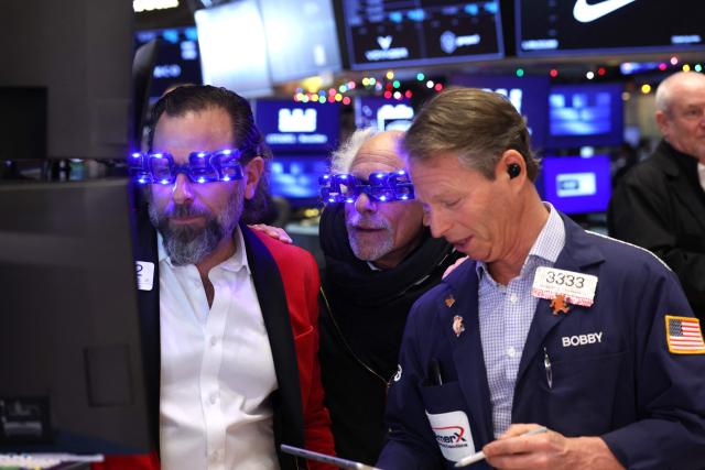 Traders wear "2026" glasses as they work on the floor of the New York Stock Exchange (NYSE) at the opening bell in New York on December 31, 2025. (Photo by TIMOTHY A. CLARY / AFP)