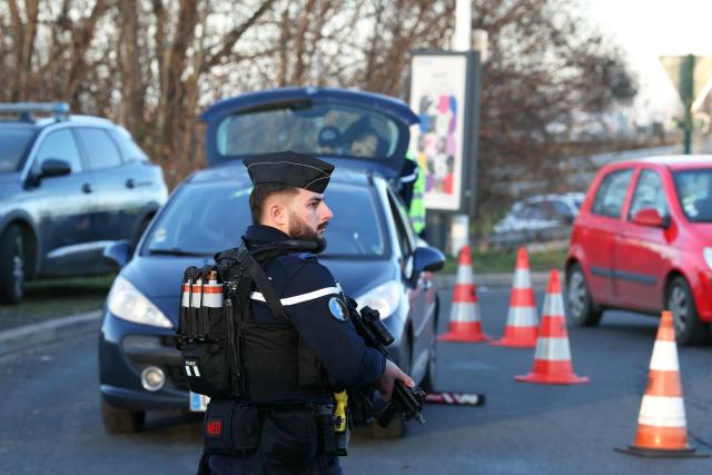 A French gendarme stands at a checkpoint during France's Interior Minister's visit to the presentation of a security procedure ahead of New Year's Eve, in Domont, a suburb of Paris, on December 31, 2025. (Photo by Alain JOCARD / POOL / AFP)