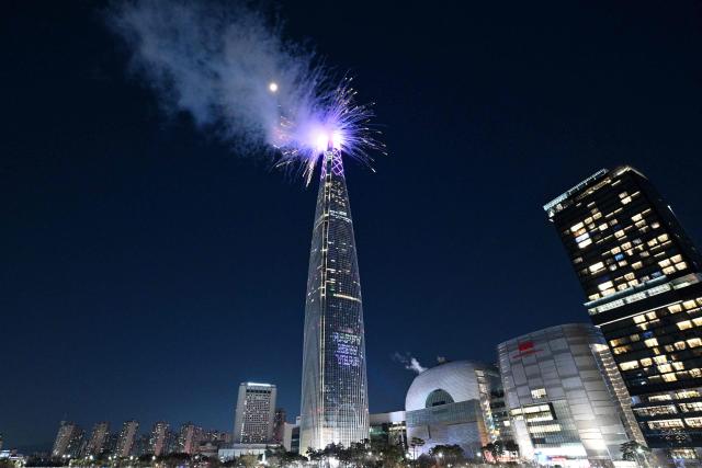 Fireworks light up the midnight sky over the Lotte World Tower, South Korea's tallest building in Seoul during New Year’s Day celebrations on January 1, 2026. (Photo by Jung Yeon-je / AFP)