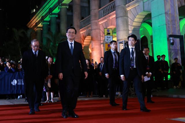 Chief Executive of Hong Kong John Lee (2L) arrives at the New Year’s countdown celebrations in Central, Hong Kong, on December 31, 2025. (Photo by May JAMES / AFP)