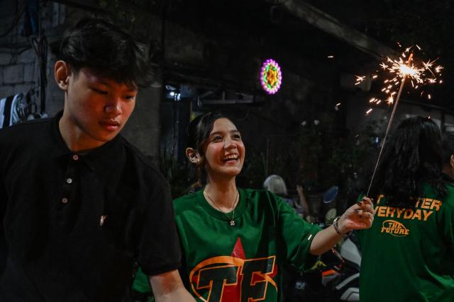 A girl holds a sparkler during New Year celebrations in Makati, Metro Manila on January 1, 2026. (Photo by Jam STA ROSA / AFP)