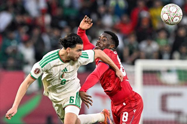 Algeria's midfielder #6 Ramiz Zerrouki and Equatorial Guinea's midfielder #08 Jannick Buyla jump for a header during the Africa Cup of Nations (CAN) Group E football match between Equatorial Guinea and Algeria at Moulay Hassan Stadium in Rabat on December 31, 2025. (Photo by Gabriel BOUYS / AFP)